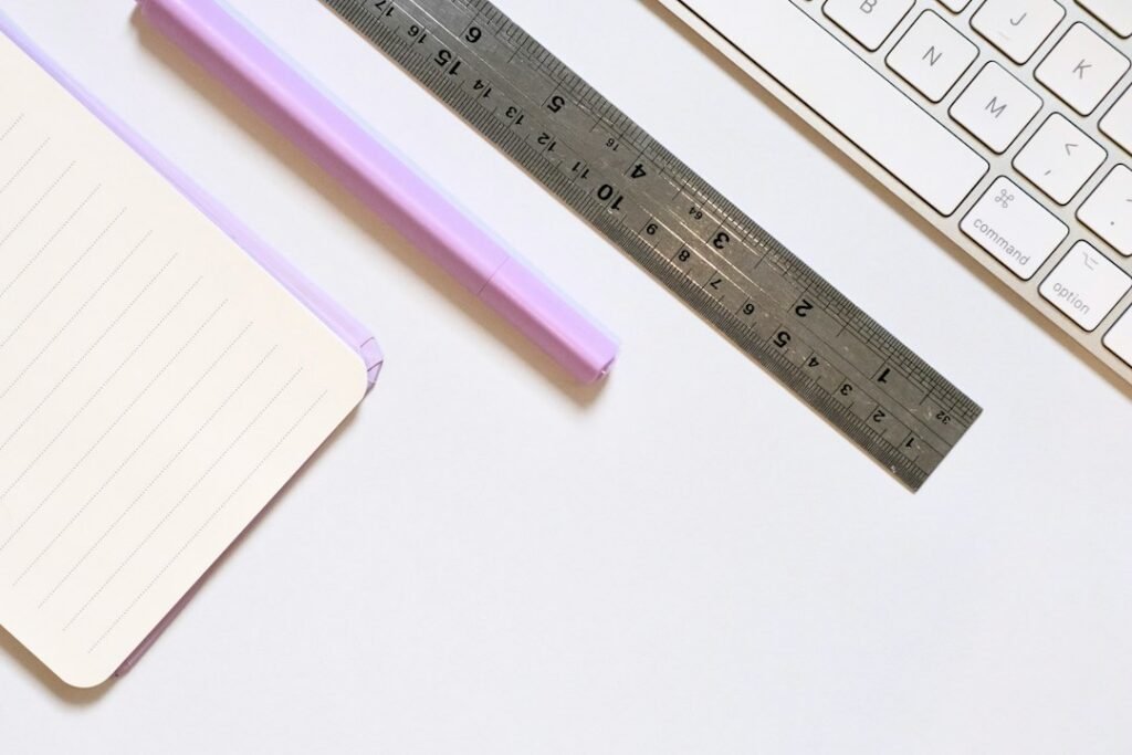Notebook, pencil, ruler and keyboard arranged on a bright desk for a game-planning workflow