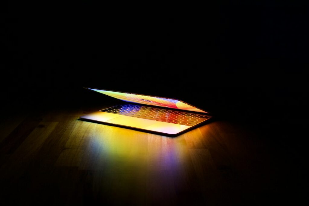 Colorfully illuminated laptop on a desk illustrating browser game and software development